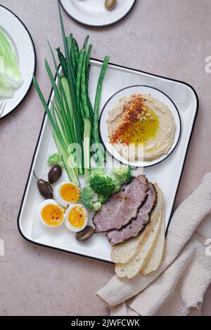 Frühstück mit hinterem Fleisch, Hummus und grünem Gemüse, Kopierplatz Stockfoto