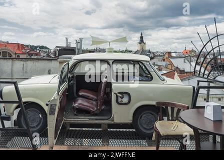 Trabant Auto geparkt auf dem Dach des historischen Gebäudes House of Legends, berühmtes Café, Wahrzeichen und Reiseziel von Lviv, Ukraine Stockfoto