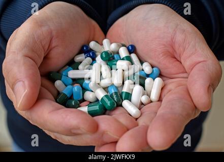 Verschiedene Pillen in männlichen Händen Stockfoto