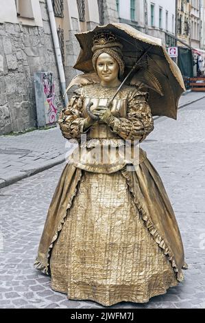 Nicht identifizierte Straßenmusikmime im Retro-Kostüm mit Regenschirm auf der Straße von Lviv, Ukraine Stockfoto