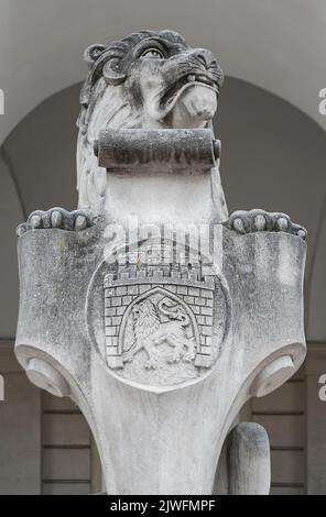 Nahaufnahme der Steinskulptur des sitzenden Löwen mit der Stadt Lemberg antikes Wappenhaus am Eingang des Rathauses, Ukraine Stockfoto