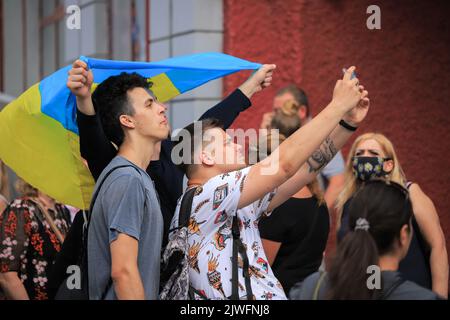 Kiew, Ukraine - 24. august 2021: Junge Männer werden am Unabhängigkeitstag der Ukraine unter der Flagge der Ukraine fotografiert Stockfoto