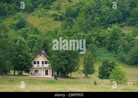 Landhaus am Wald in den Bergen Stockfoto
