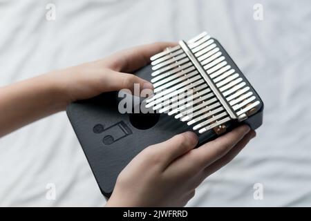 Nahaufnahme eines afrikanischen Musikinstruments in der Hand oder einer Person, die auf Kalimba spielt Stockfoto