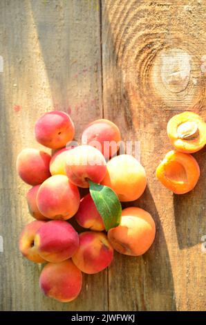 Pfirsichmarmelade im Glas mit Pfirsichkeilen und ganzen Früchten. Pfirsichmarmelade auf Holztisch. Konserve mit Zutaten Stockfoto