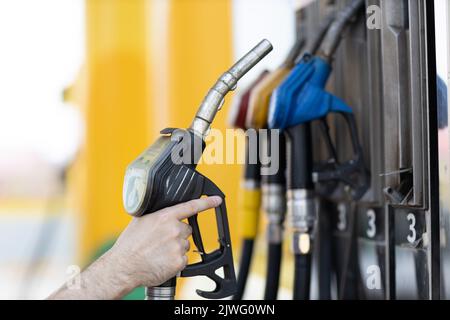 Mann, der an der Tankstelle eine Füllpistole in der Hand hält. Stockfoto
