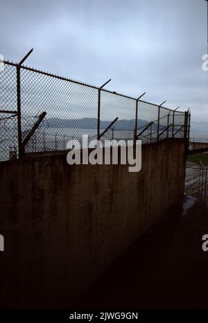 Alcatraz National Park, USA 6/1985. Alcatraz Island: Eine kleine Insel in der Bucht von San Francisco, 1,25 Meilen (2,01 km) vor der Küste von San Francisco, Kalifornien, USA. Mitte des 19.. Jahrhunderts war Alcatraz ein Leuchtturm, eine militärische Festung und ein Militärgefängnis. Im Jahr 1934 wurde die Insel in ein Bundesgefängnis, Alcatraz Federal Penitentiary, umgewandelt. Die Bucht von San Francisco hat starke Strömungen rund um die Insel und die kalten Wassertemperaturen machten eine Flucht fast unmöglich. Das Gefängnis wurde zu einem der berüchtigtsten in der amerikanischen Geschichte. Das Gefängnis schloss 1963 und die Insel ist heute ein wichtiger Tourist. Stockfoto