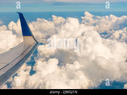 Flugzeugflügel und Wolken vom Flugzeugfenster aus gesehen Stockfoto