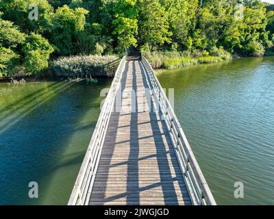 Blick von einer Drohne auf die Holzbrücke im Sunken Meadow State Park an einem sonnigen Tag. Stockfoto
