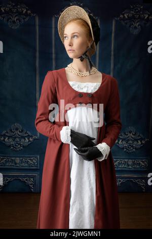 Eine Regency-Frau, die ein weißes, besticktes Musselin-Kleid mit einem langen spencer über der Oberseite trägt Stockfoto