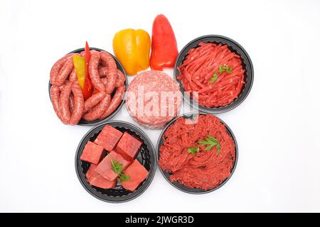 Top-Ansicht von ausgewählten rohen Rindfleischprodukten Würstchen, Hackfleisch, Burger Patty, Beef Cubes und Streifen isoliert auf weißem Hintergrund Stockfoto
