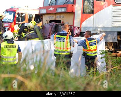 (220906) -- KUNFEHERTO, 6. September 2022 (Xinhua) -- Polizei und Feuerwehrleute arbeiten am 5. September 2022 am Unfallort in der Nähe von Kunfeherto, Ungarn. Sieben Menschen sind gestorben, nachdem Anfang Montag ein Auto mit einem Zug in Südungarn kollidierte, teilte die Polizei mit. (Ferenc Donka/MTI über Xinhua) Stockfoto