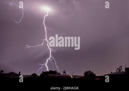 Blitz in Arizona über Phoenix. Farbige, bewölkte Wolken; heller Punkt in Wolken, an dem die Hauptschraube ausstrahlt und auf den Boden fällt. Stockfoto