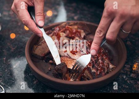 Brisket aus einem Holzofen, serviert auf einer Keramikplatte. Vorderansicht. Stockfoto