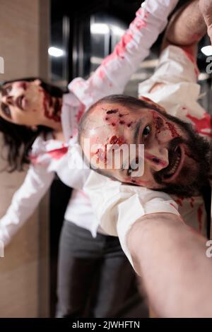 Porträt von gruseligen Leiche Angriff Büro, Flucht Aufzug und sieht gefährlich mit blutigen Narben. Unheimliche, aggressive Zombies, die erschreckend sind und Menschen nachjagen, Gehirn fressen Wanderer. Stockfoto