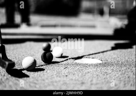 Minigolf-Spiel mit mehreren farbigen Kugeln in der Art eines Putter aufgereiht. Stockfoto