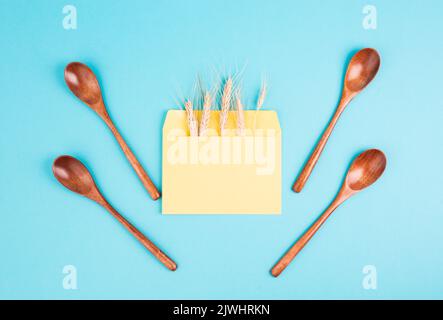 Umschlag mit Weizenohren und leeren Löffeln, Lebensmittelknappheit und steigenden Preisen, Armut durch Inflation Stockfoto