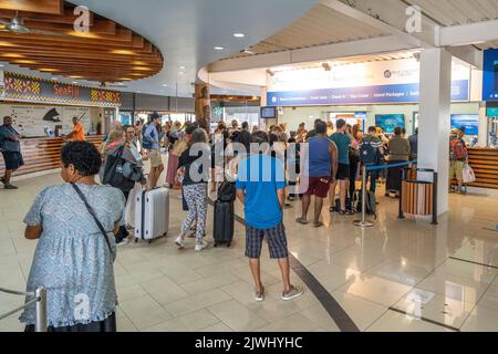 Touristen und Urlauber, die am Fährhafen Port Denarau, Nadi, Fidschi, Schlange stehen, um Tickets zu erhalten Stockfoto