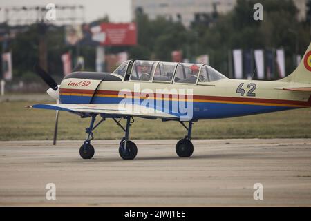 Bukarest, Rumänien - 4. September 2022: Yakovlev Yak-52 Flugzeug auf dem Aurel Vlaicu Flughafen in Bukarest während einer Flugshow. Stockfoto