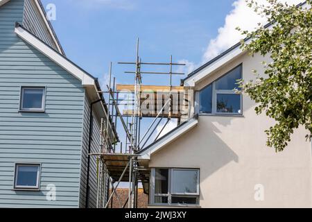 Gerüste, die bis zum Dach eines modernen Hauses gehen Stockfoto