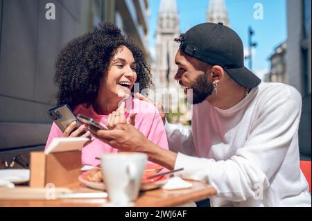 Junger Mann und junge Frau fühlen sich kokett und glücklich Stockfoto