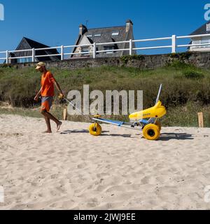 In Saint-Cast-le-Guildo, einer Gemeinde im Département Côtes-d'Armor der Bretagne im Nordwesten Frankreichs, können Menschen mit Behinderungen mit Rollstuhl den Strand erreichen und schwimmen. Stockfoto