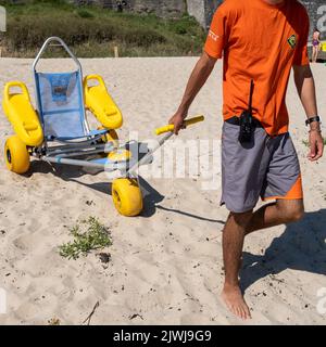 In Saint-Cast-le-Guildo, einer Gemeinde im Département Côtes-d'Armor der Bretagne im Nordwesten Frankreichs, können Menschen mit Behinderungen mit Rollstuhl den Strand erreichen und schwimmen. Stockfoto