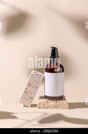 Brown Glass Cosmetic eine Pumpflasche auf Travertinstein auf hellbeige, harte Schatten, Nahaufnahme, Etikettenmockup. Hautpflegeprodukt, Lotion oder esse Stockfoto