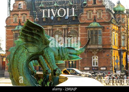 Bronzestatue, die einen Chimäre-Drachen darstellt, mit einem der Eingänge zum Vergnügungspark Tivoli dahinter. Kopenhagen, Dänemark, Europa Stockfoto