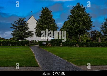 Die Kirche von Jelling steht auf dem Grab des ersten Wikingers, der das Christentum in Dänemark angenommen hat.an seiner Seite erzählen die Runensteine die Geschichte.Welterbe Stockfoto