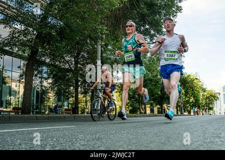 Jekaterinburg, Russland - 7. August 2022: Blinder Athlet-Läufer mit seinem Führungslauf beim Europa-Asien-Marathon Stockfoto