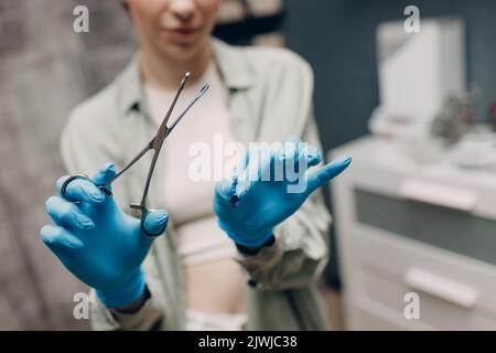 Junge Frau macht Ohrpiercing im Schönheitssalon Stockfoto