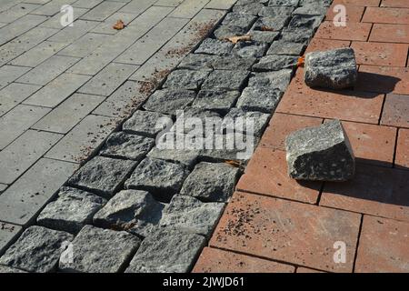 Betonfertiger Design in Pflasterung Gehwege. Die Kombination von wildem Gestein und Betonfertigern in verschiedenen Farben in Betonpflaster. Stockfoto