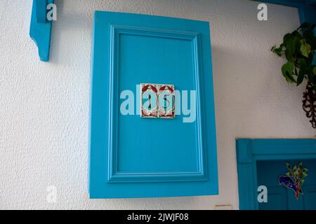 Hausnummernschild an der Wand. Adressnummer auf weißer Mauer in der Altstadt von Marmaris. Marmaris, Türkei - 8. September 2021 Stockfoto