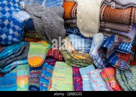 Viele verschiedene Baumwollsocken und gestrickte Wintersocken aus Wolle, Draufsicht. Handgefertigt. Stockfoto