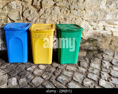 Mehrfarbige Kunststoffbehälter für die separate Müllabfuhr. Das Konzept des Umweltschutzes vor Verschmutzung. Inschriften in rumänischer Sprache. Ru Stockfoto