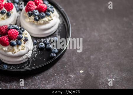 Mini Pavlova Kuchen mit Beeren und Mascarpone-Käse gekrönt Stockfoto