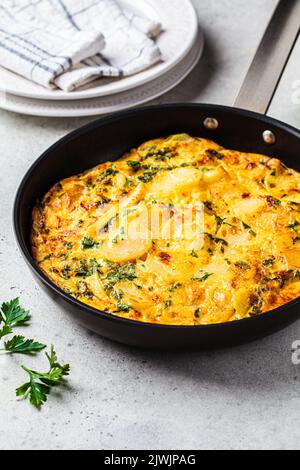 Traditionelle spanische Kartoffeltortilla oder Omelette in einer schwarzen Pfanne. Stockfoto