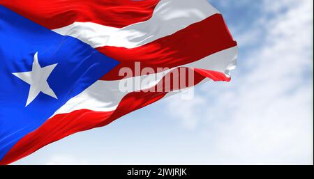 Die Flagge von Puerto Rico winkt an einem klaren Tag im Wind. Puerto Rico ist eine karibische Insel und ein nicht eingebautes Gebiet der Vereinigten Staaten Stockfoto