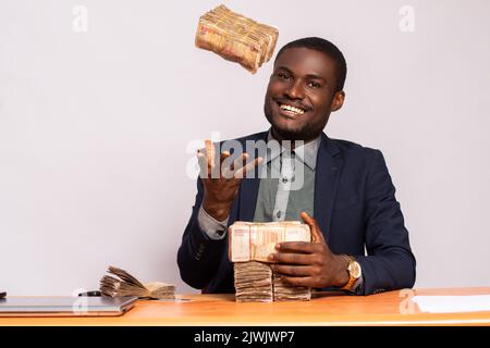 Glücklicher afrikanischer Geschäftsmann mit viel Geld Stockfoto