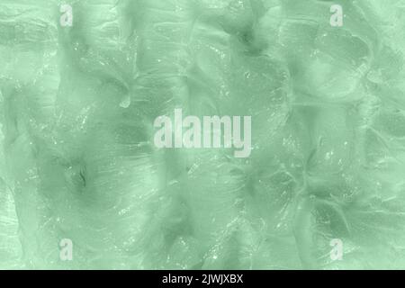 Flüssiges grünes Balsam mit verschmiertem Gewebe. Das Konzept der Naturkosmetik. Selbstgemachte Bienenwachs-Probe. Aloe Vera kosmetische Gel Textur Hintergrund. Hautpflege Stockfoto