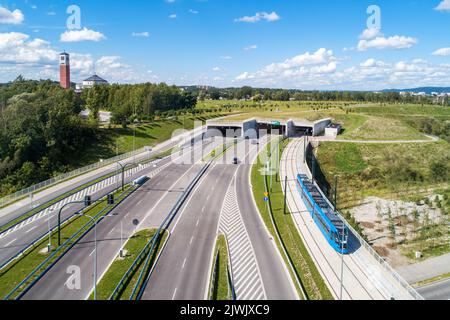 Neue Stadtautobahn in Krakau, Polen, genannt Trasa Łagiewnicka mit separaten Tunneln für Autos und Straßenbahn mit Verkehr und Straßenbahn. Teil der Ringstraße Stockfoto