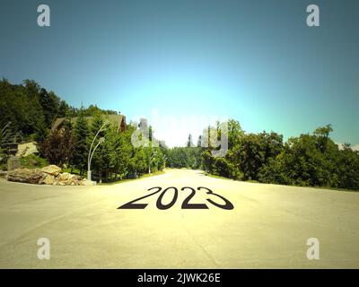 2023 geschrieben auf einer Straße inmitten einer leeren Straße und einer wunderschönen Landschaft. Konzept für die Vision des neuen Jahres 2023. Stockfoto