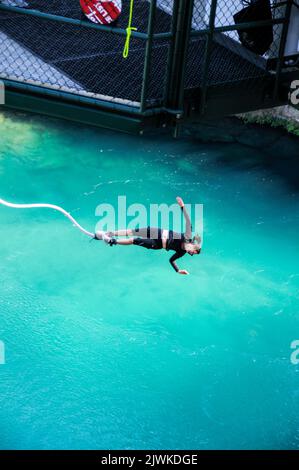 Ein mit einer elastischen Kordel verbundener Bungy-Jumper stürzt sich 47 Meter unterhalb des neuen Taupo Cliff Hanger in den Waikato-Fluss (Neuseelands längster Fluss) Stockfoto