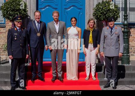 06. September 2022, Nordrhein-Westfalen, Düsseldorf: Der britische Prinz Harry (3. v.l.) und seine Frau Meghan (3. v.l.), Herzogin von Sussex, kommen vor dem Rathaus an und stehen zusammen mit Alfred Marstaller, Brigadier General (l), Stephan Keller (CDU, 2. v.l.), Oberbürgermeister der Landeshauptstadt Düsseldorf, Siemtje Möller Parlamentarischer Staatssekretär beim Bundesminister der Verteidigung (2. v.r.) und Markus Laubenthal, Generalleutnant. Der Prinz und seine Frau kommen nach Düsseldorf, um für die Invictus Games 2023 zu werben, an denen Prinz Harry mitgewirkt hat Stockfoto