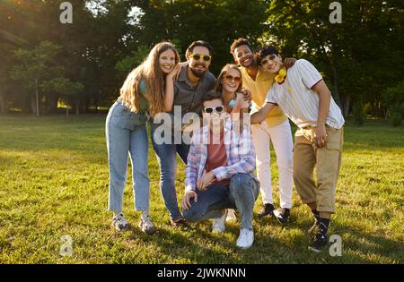 Junge, freundliche, multiethnische Menschen in legerer Kleidung, die nach einem gemeinsamen Spaziergang im Sommer mit einem Lächeln posieren Stockfoto
