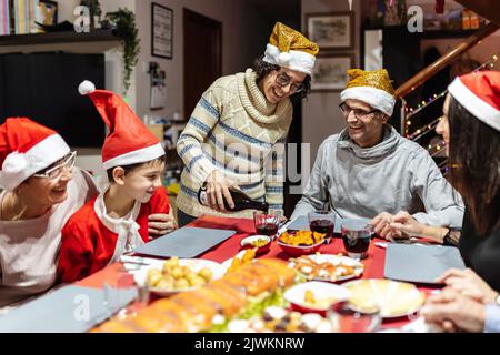 Glückliche Familie, die Spaß am weihnachtstisch hatte Stockfoto