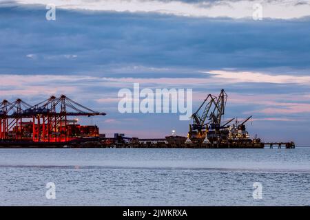 Jade-Weser-Port, Containerterminal in Wilhelmshafen, Umschlag eines großen Containerschiffes (links und ein Stückgutschiff (rechts) Stockfoto