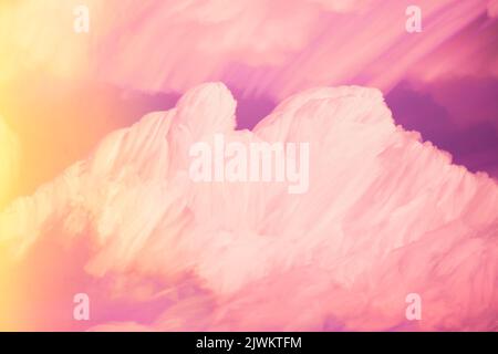 Abstrakt gesättigte rosa-gelbe Wolkenfarben. Ungewöhnlicher Himmel Hintergrund. Satte Magenta-Farben. Wolkiger Himmel. Sonnige Wolkenlandschaft Stockfoto