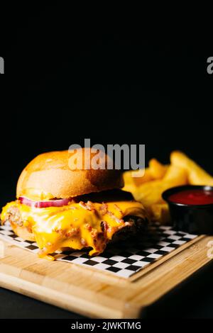 Doble Burger mit geschmolzenem Käse und gekrönt mit Speck auf schwarzem Hintergrund Stockfoto